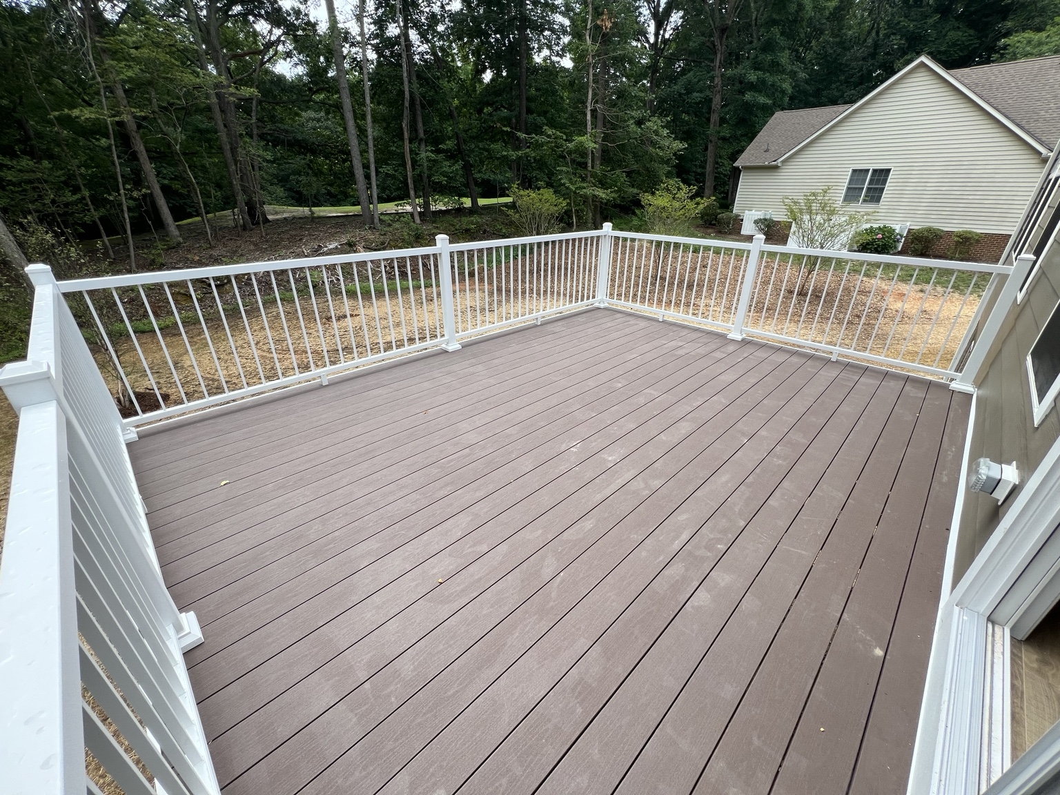 Brown deck & white railing: A spacious deck with a clean white railing surround